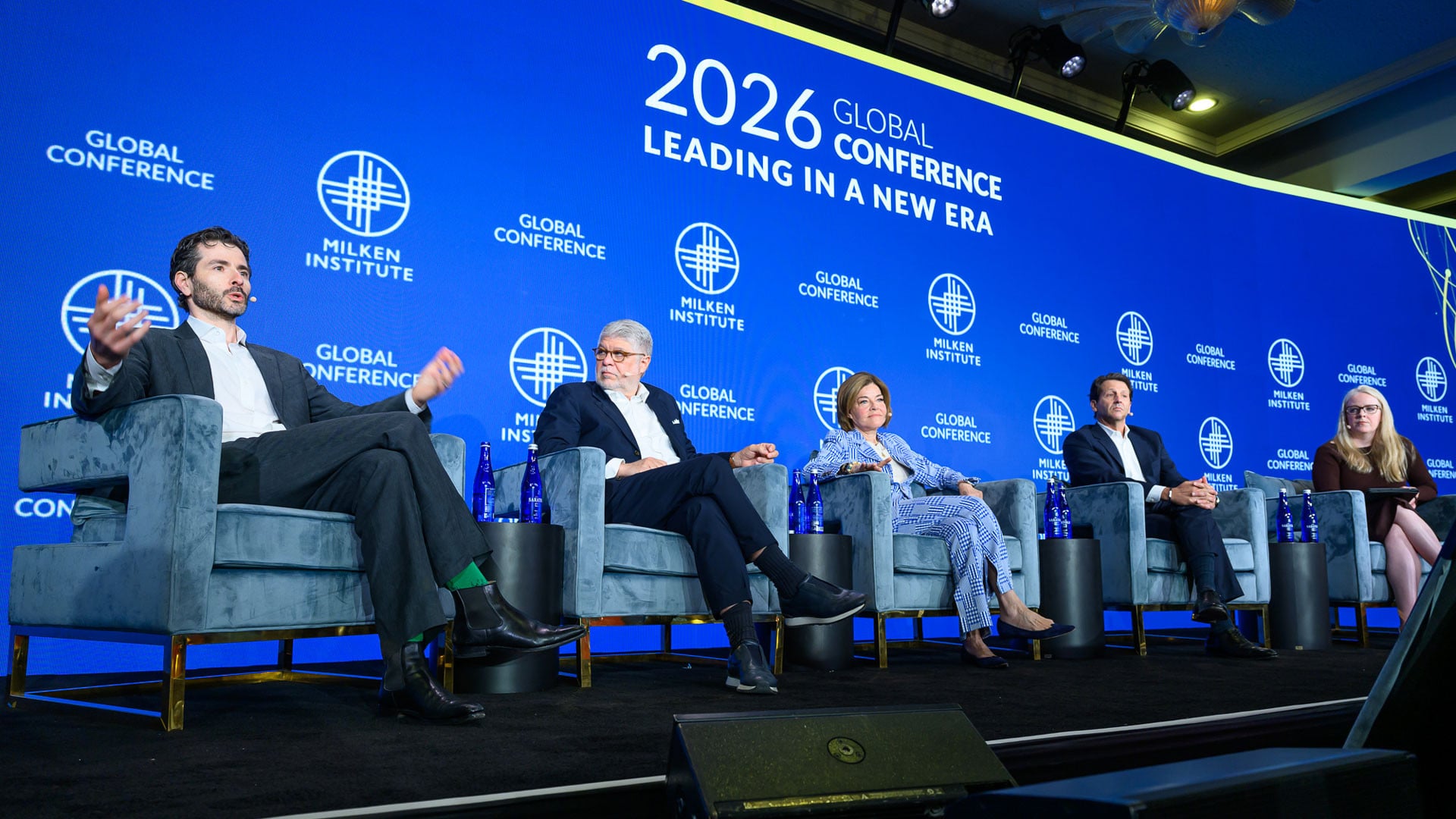 Panel discussion at 2026 FIFA World Cup event with speakers seated on stage under blue branded backdrop