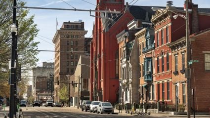 Historic urban street with colorful brick buildings and parked cars on a sunny day