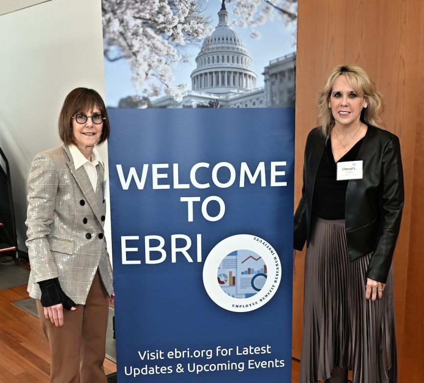 Two women stand on either side of an event pop-up banner