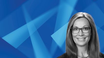Professional headshot of smiling woman with glasses against blue geometric background