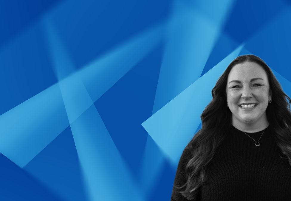 Smiling woman with long dark hair against abstract blue geometric background